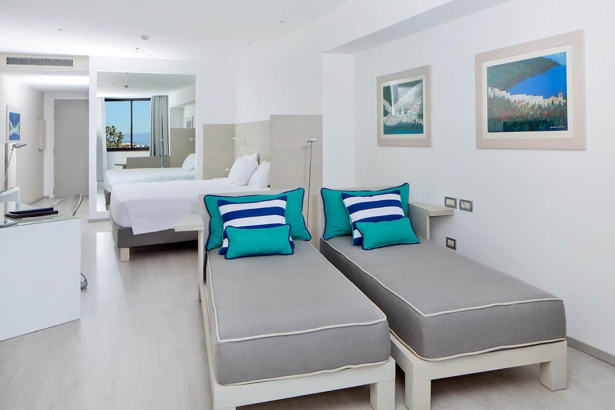 Deluxe Quadruple Room, Sea View | Minibar, in-room safe, desk, laptop workspace