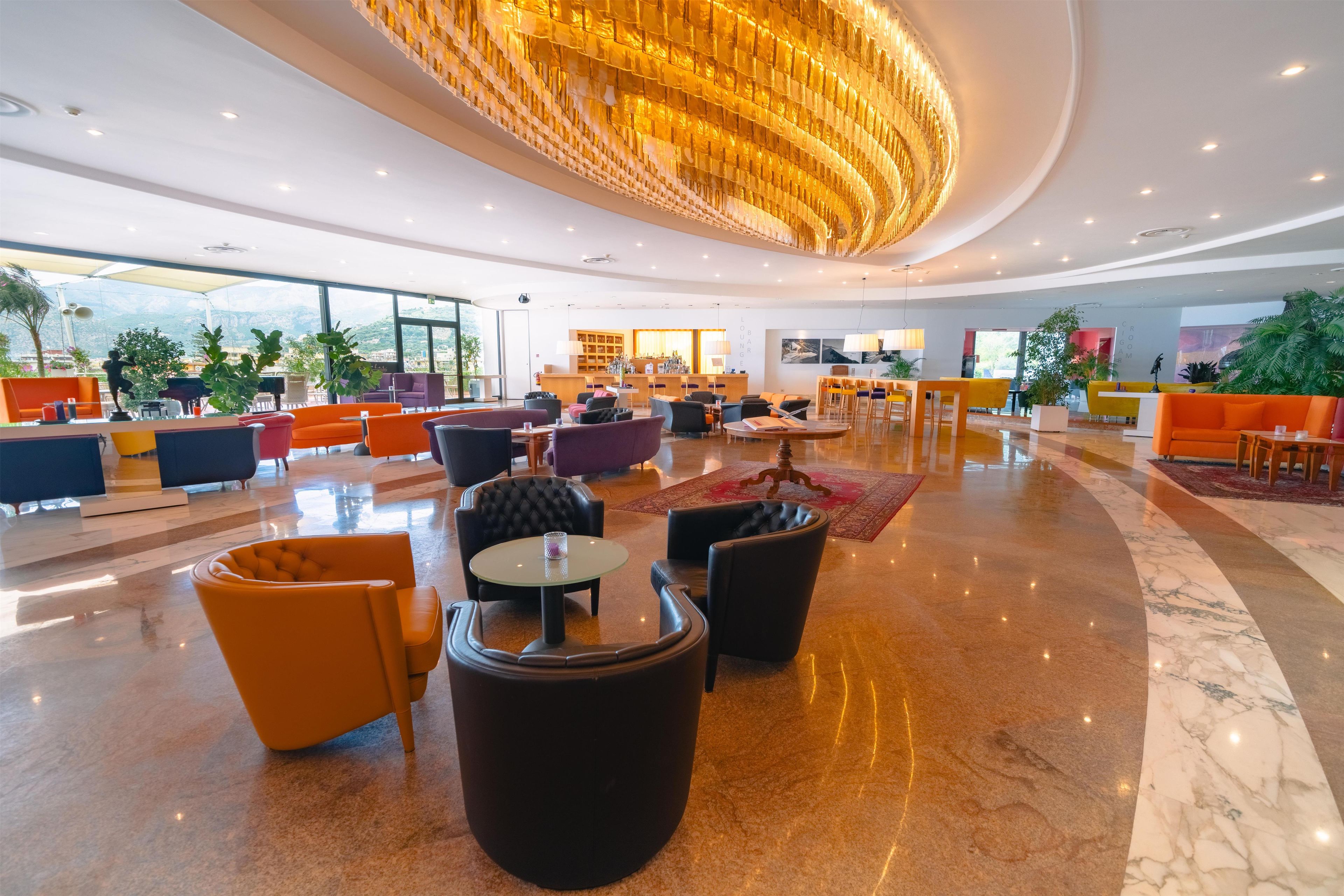 A spacious lobby with a central bar area, seating arrangements, and a view of the outdoors.