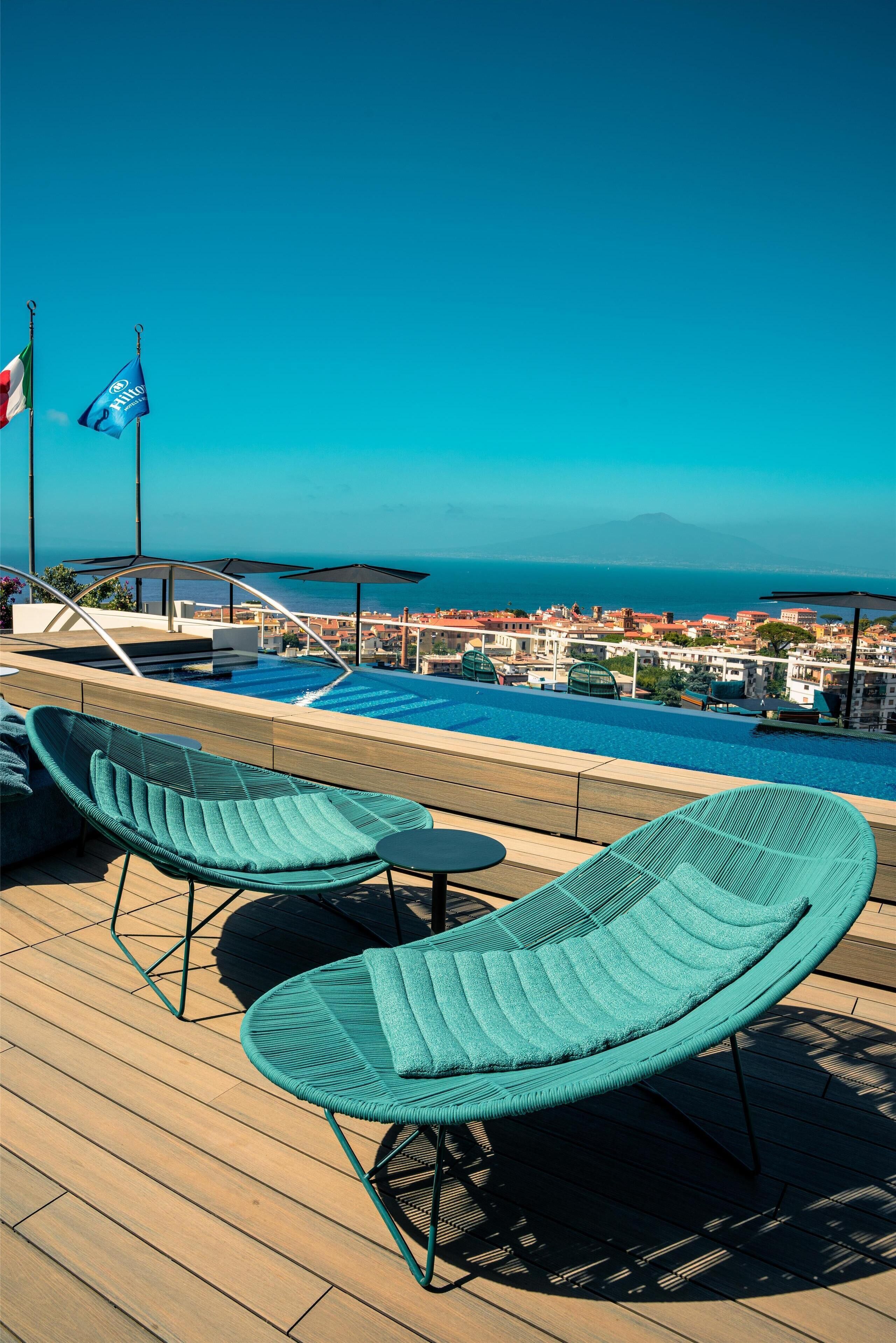 Una piscina techada, una piscina al aire libre de temporada, sombrillas