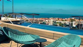 Una piscina techada, una piscina al aire libre de temporada, sombrillas