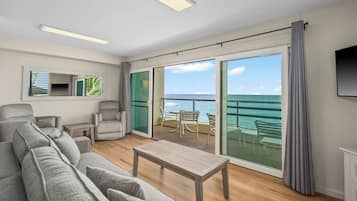 Deluxe Condo, 1 Bedroom, Oceanfront | Living room | 65-inch flat-screen TV with cable channels