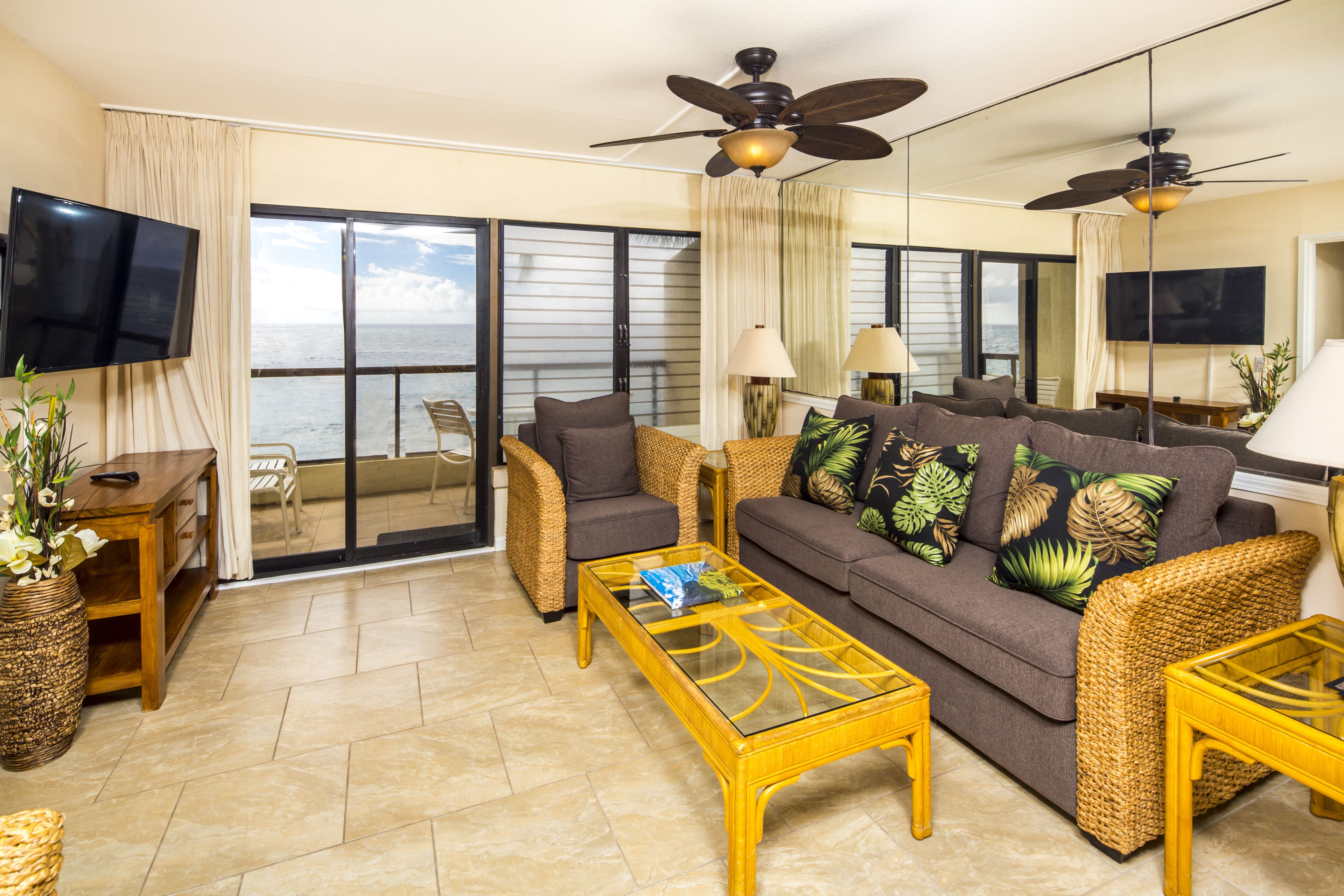 A living room with a sofa, two armchairs, a coffee table, and a TV.