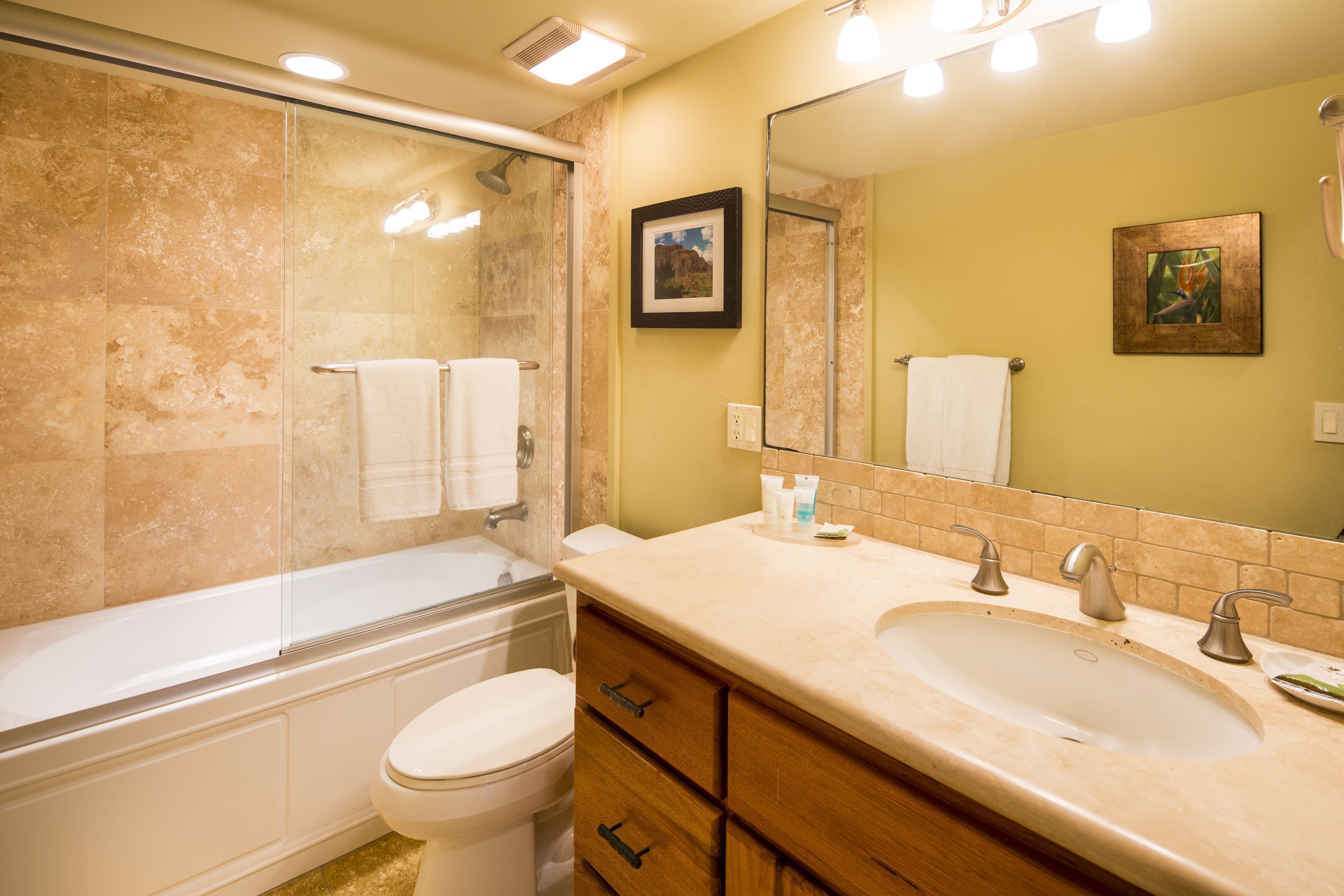 A bathroom with a bathtub, toilet, sink, and vanity.