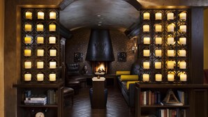 A cozy lounge area with a fireplace, bookshelves, and comfortable seating. - Royal Palms Resort and Spa, part of Hyatt (Phoenix)