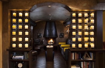 A spacious living room with a fireplace, wooden ceiling beams, and a chandelier. at Royal Palms Resort and Spa, part of Hyatt