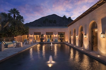 A cozy lounge area with a fireplace, bookshelves, and comfortable seating. at Royal Palms Resort and Spa, part of Hyatt