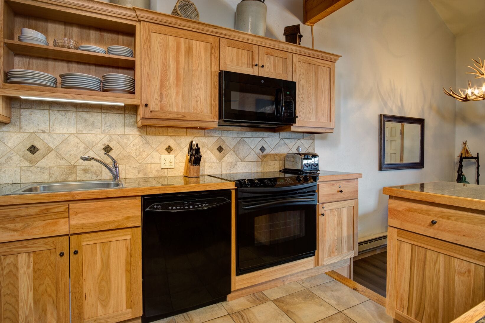 A kitchen with wooden cabinets, a microwave, a dishwasher, and a stove.