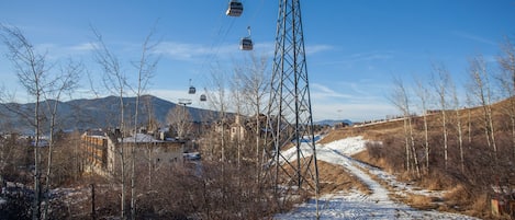 A snowy landscape with a ski lift and a path leading to buildings.