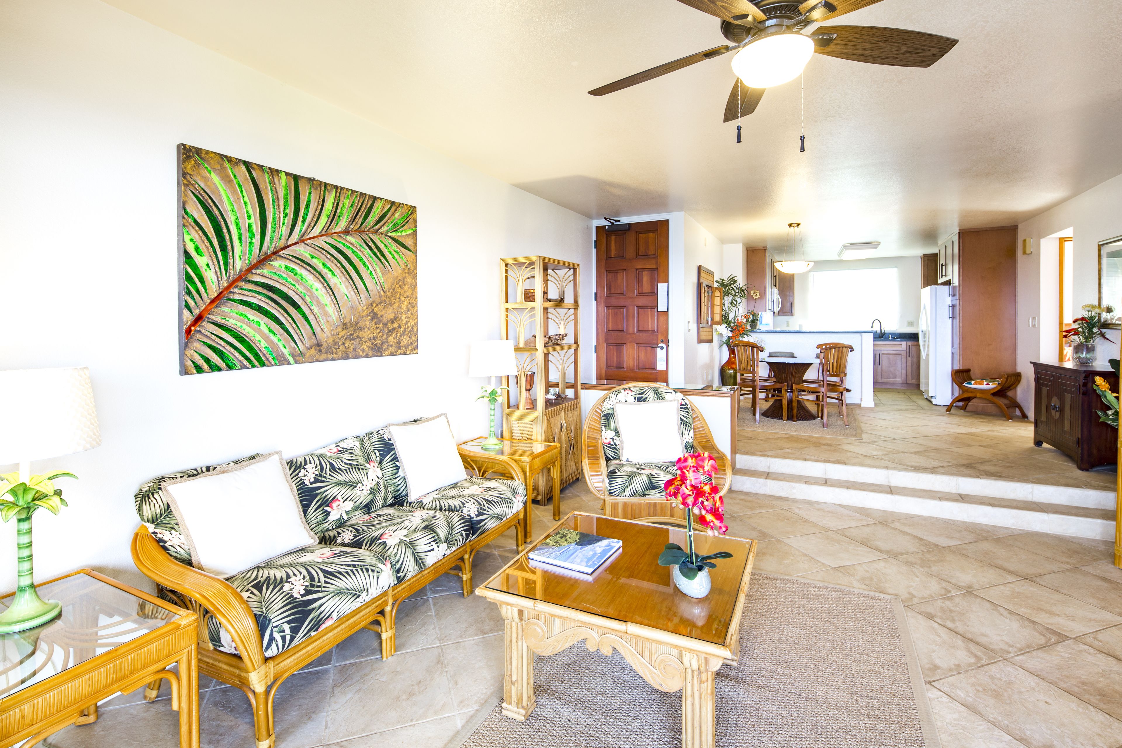 A living room with a sofa, coffee table, and a painting on the wall.