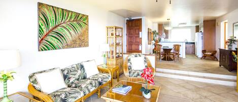A living room with a sofa, coffee table, and a painting on the wall.
