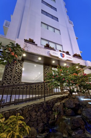 A hotel with a modern facade, a stone water feature, and a sign indicating it is a 'Stay Waikiki' location. - Stay Hotel Waikiki (Honolulu)