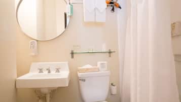 Un baño con lavamanos, inodoro y cortina de ducha blanca.