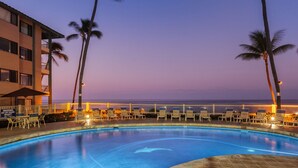 A pool area with lounge chairs and palm trees, overlooking a body of water. - Castle at Kona Reef (Kailua-Kona)