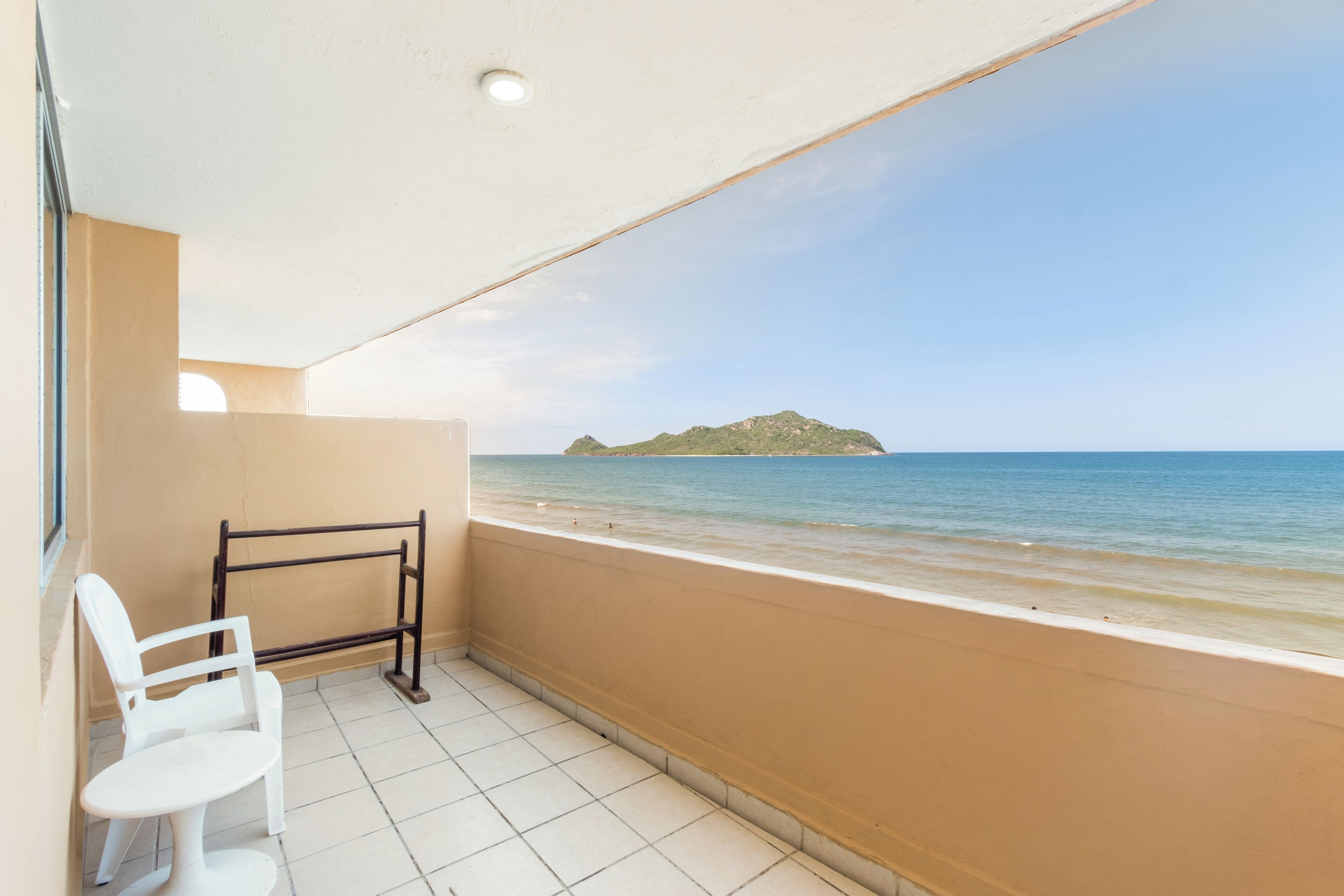 Een balkon met uitzicht op zee en een klein eiland.