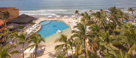 Un resort con piscina, playa y palmeras.