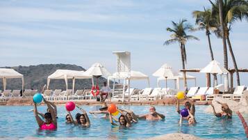 Relax by the pool surrounded by palm trees and lounge chairs.