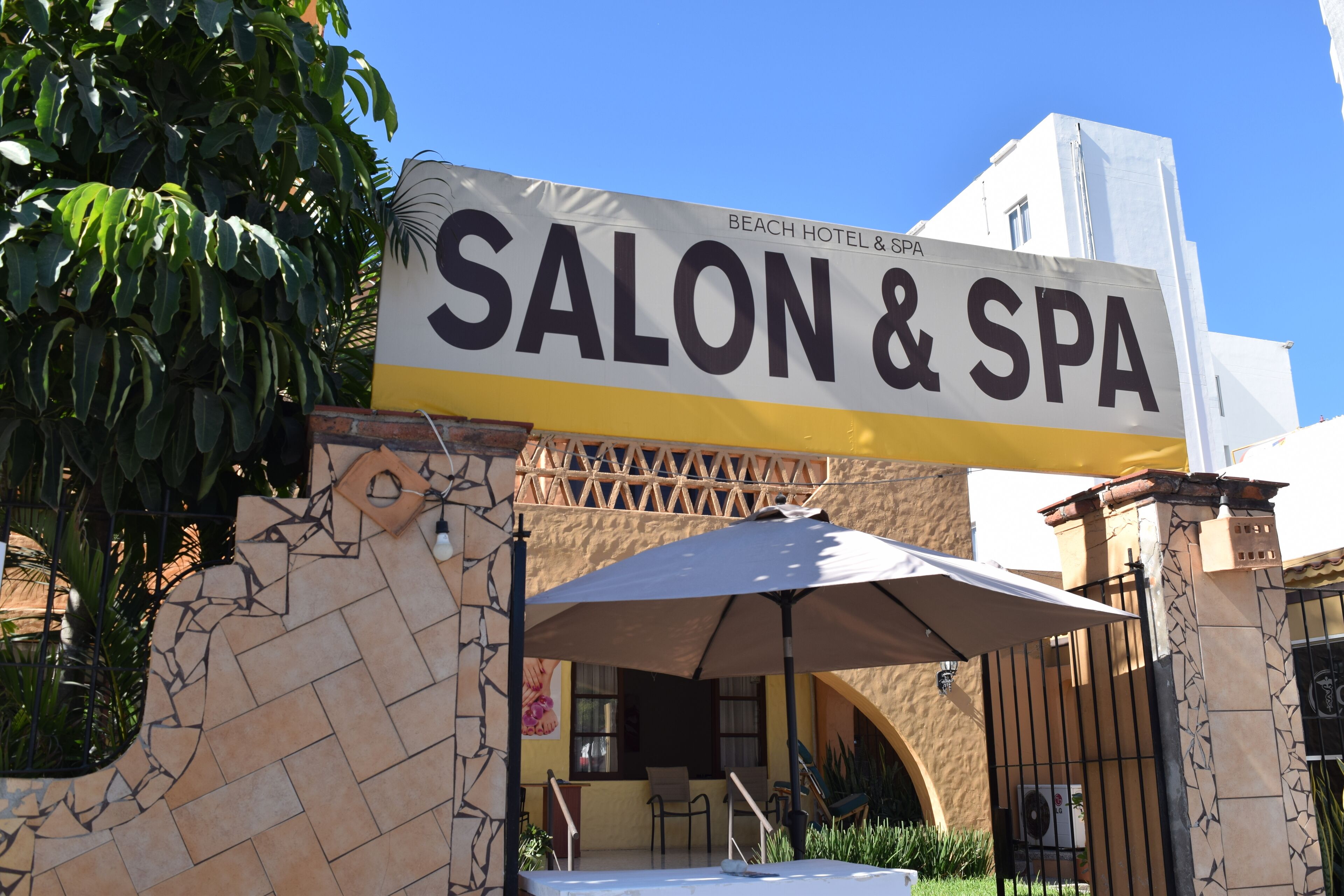 A sign for a salon and spa, indicating the presence of a beach hotel and spa.