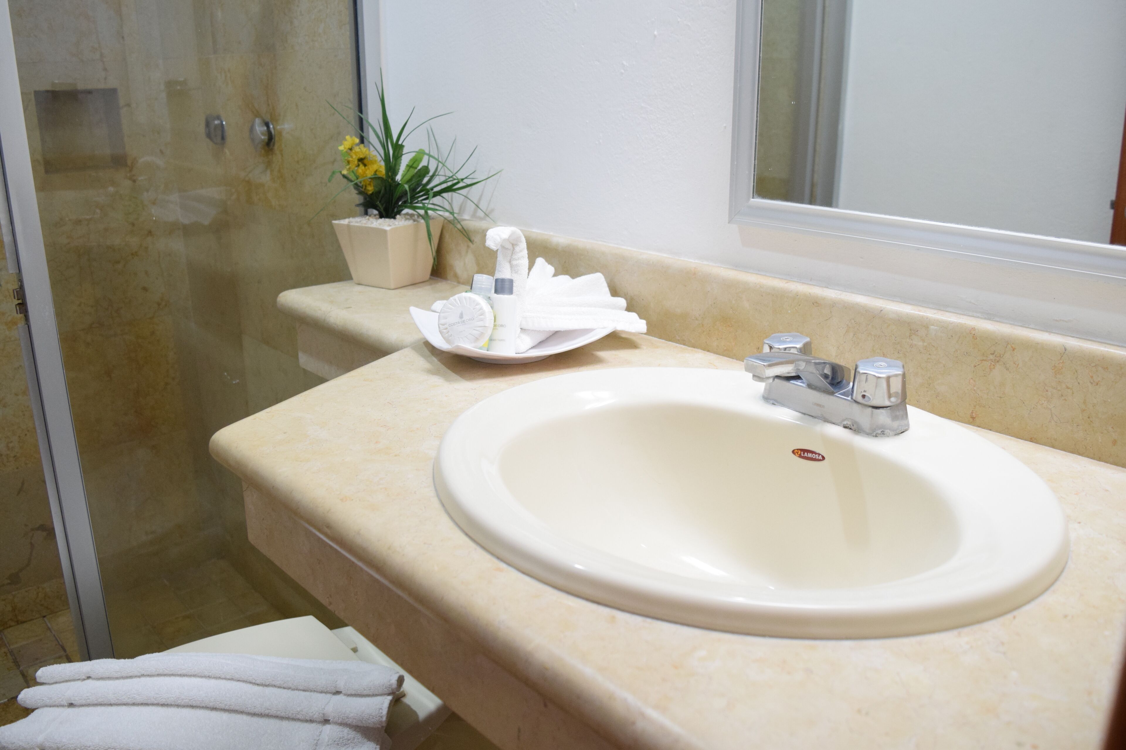 A bathroom with a sink, towel rack, and a potted plant.