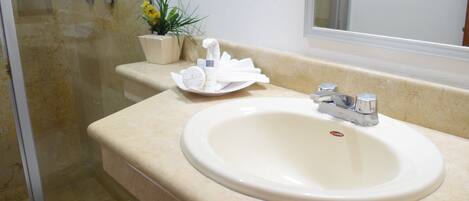 A bathroom with a sink, towel rack, and a potted plant.