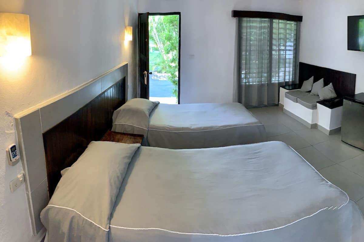 Une chambre dâhĂŽtel avec deux lits, un bureau, une tĂ©lĂ©vision et une salle de bain.