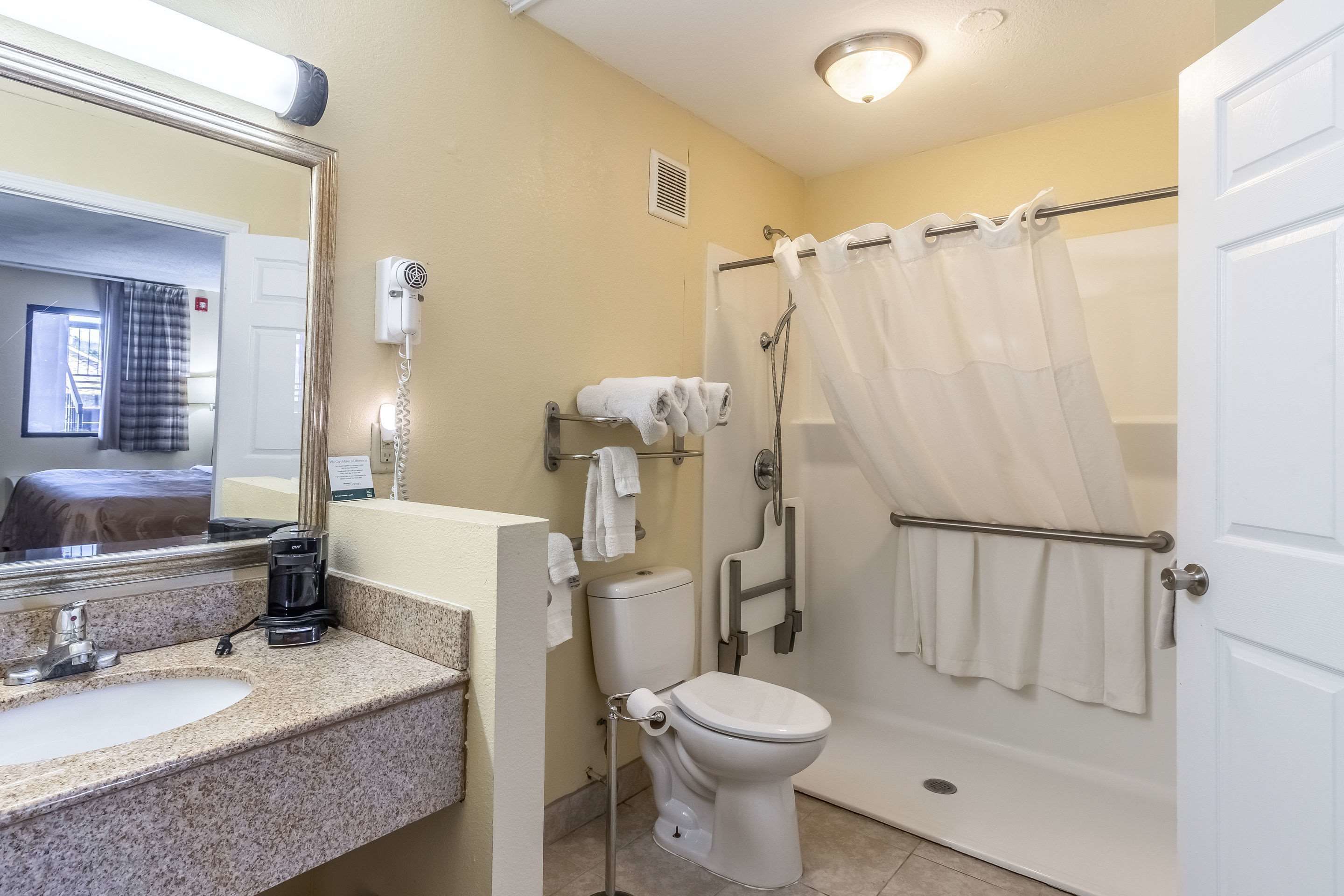 Une salle de bain équipée d’un lavabo, de toilettes, d’une douche et d’un miroir.