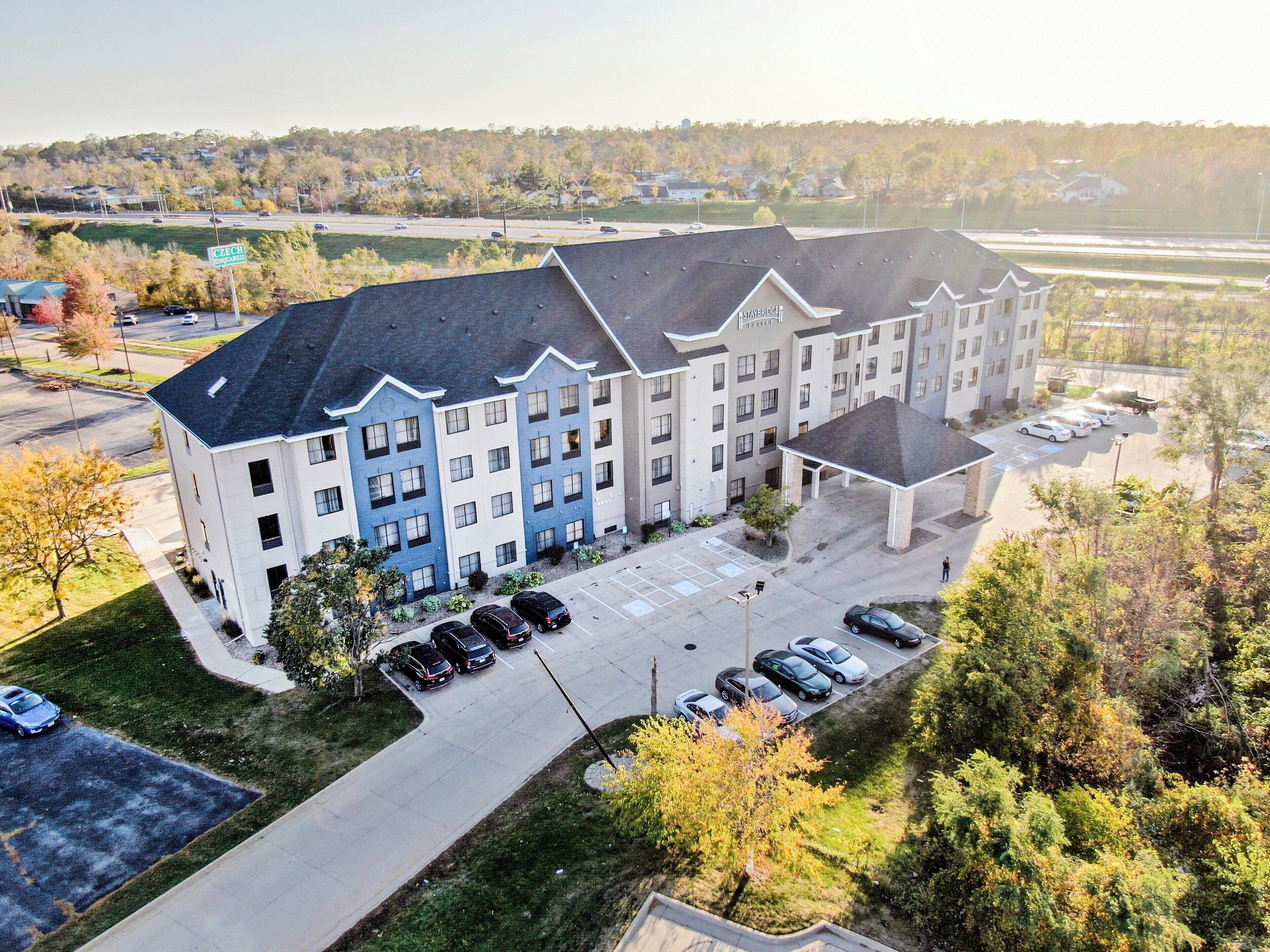 A multi-story hotel with a parking lot and a covered area.