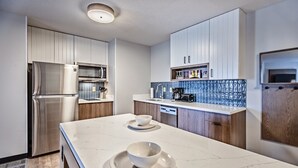 A modern kitchen with white cabinets, a stainless steel refrigerator, a coffee machine, and a dishwasher. - Staybridge Suites Cedar Rapids North by IHG (Cedar Rapids)