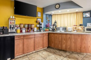 A kitchen with a bar area, equipped with coffee machines, a microwave, and a clock on the wall. - Park Inn by Radisson, Macon North (Macon)