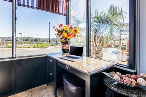 A modern room with a large window, a laptop on the desk, a vase with flowers, and a decorative tray with various items. - Park Inn by Radisson, Macon North (Macon)