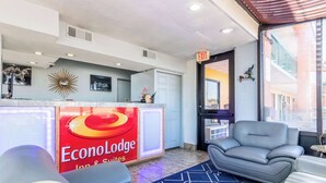 A hotel reception area with a modern design, including a reception desk, seating area with sofas, and a large window offering a view of the city. - Park Inn by Radisson, Macon North (Macon)