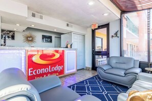 A hotel reception area with a modern design, including a reception desk, seating area with sofas, and a large window offering a view of the city. - Park Inn by Radisson, Macon North (Macon)