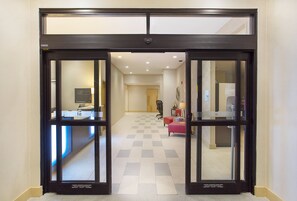 An entrance with automatic sliding doors, a reception desk, a check-in counter, and a check-in area with a desk and chairs. - Holiday Inn Express Berea by IHG (Berea)