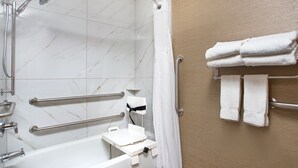 A bathroom with a walk-in shower, grab bars, a white bathtub, and towels on a rack. - Holiday Inn Express Berea by IHG (Berea)
