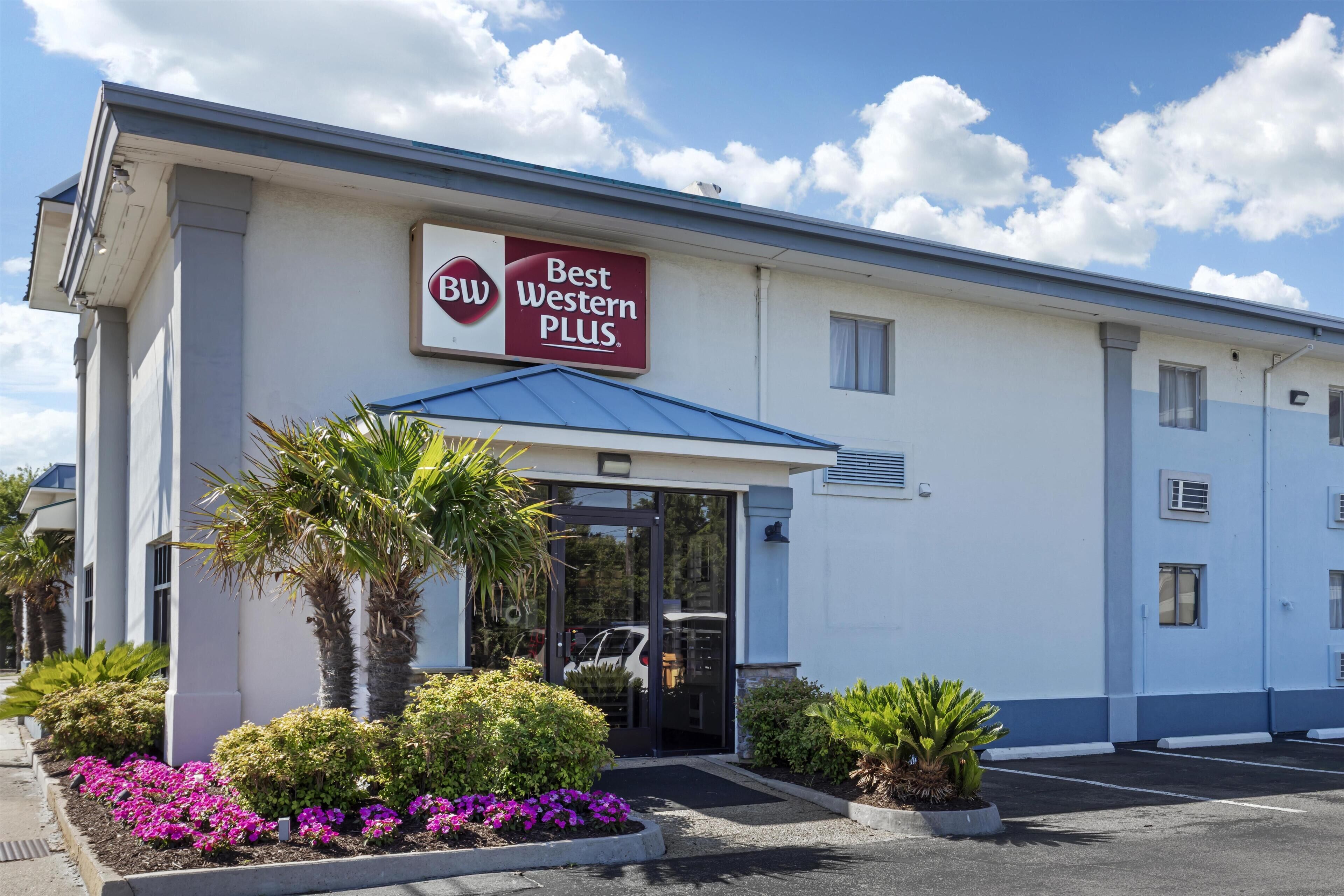 A hotel with a sign reading 'Best Western PLUS,' a covered entrance, and a parking lot.