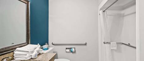 A bathroom with a sink, toilet, and shower.