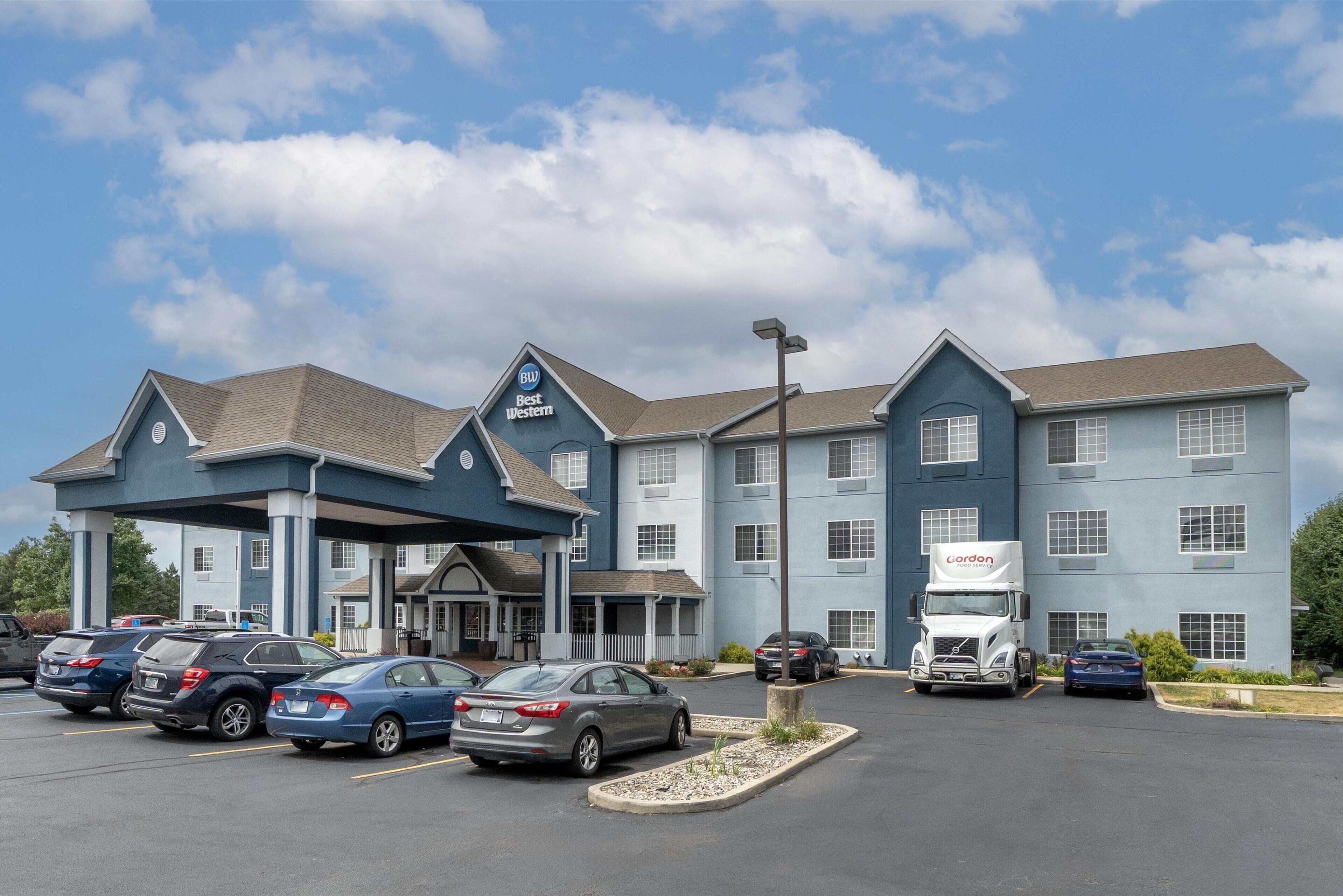 A Best Western hotel with a parking lot, a truck, and several cars.