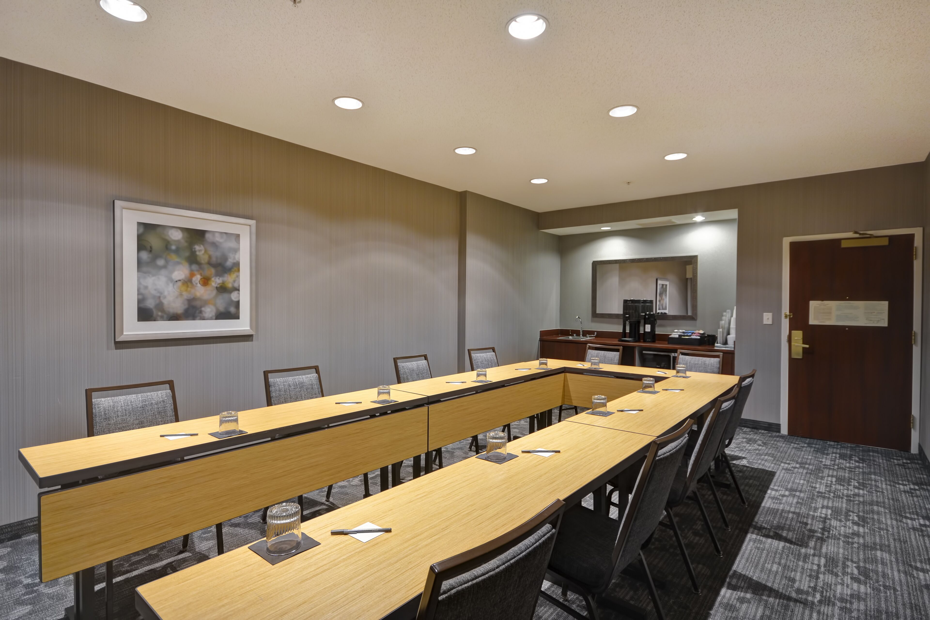 Une salle de conférence équipée d’une longue table, de chaises et d’un coin café.