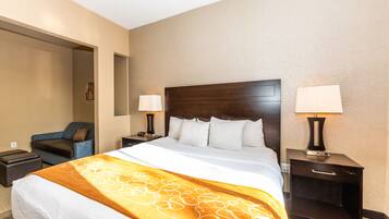 A hotel room with a large bed, two bedside tables, a nightstand, a chair, and a wall-mounted TV.