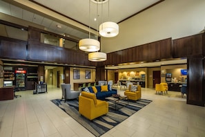 A spacious lobby with a seating area, a kitchenette, and a Coca-Cola refrigerator. - Comfort Suites Houston West at Clay Road (Houston)