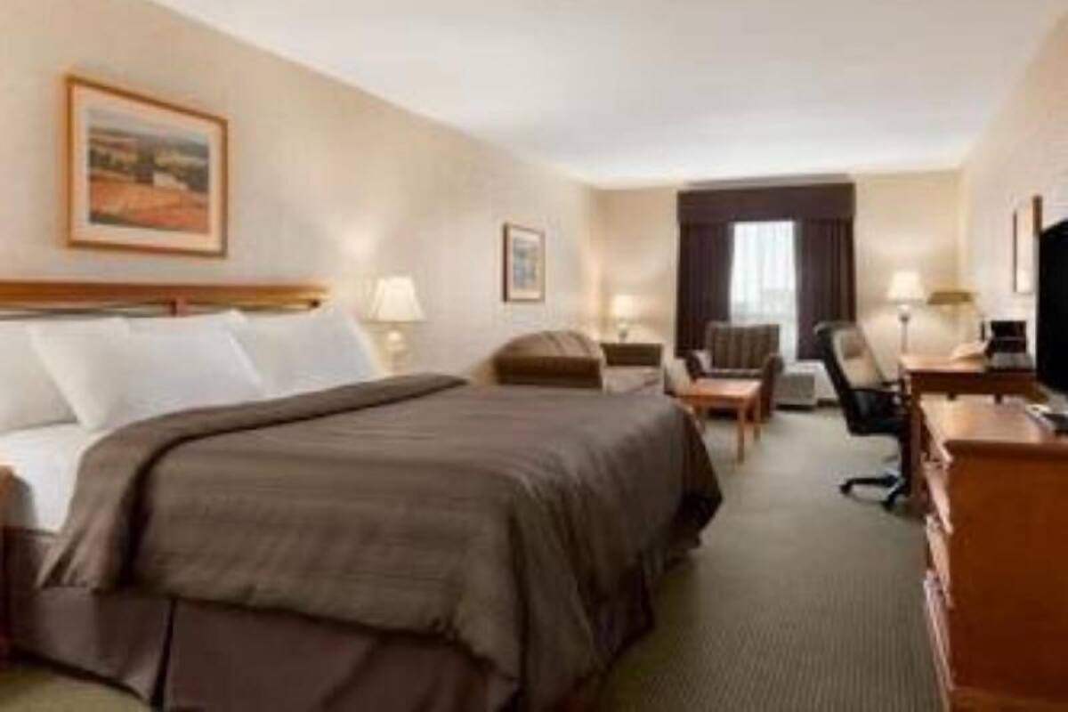 Habitación de hotel con cama, escritorio, silla y televisión.