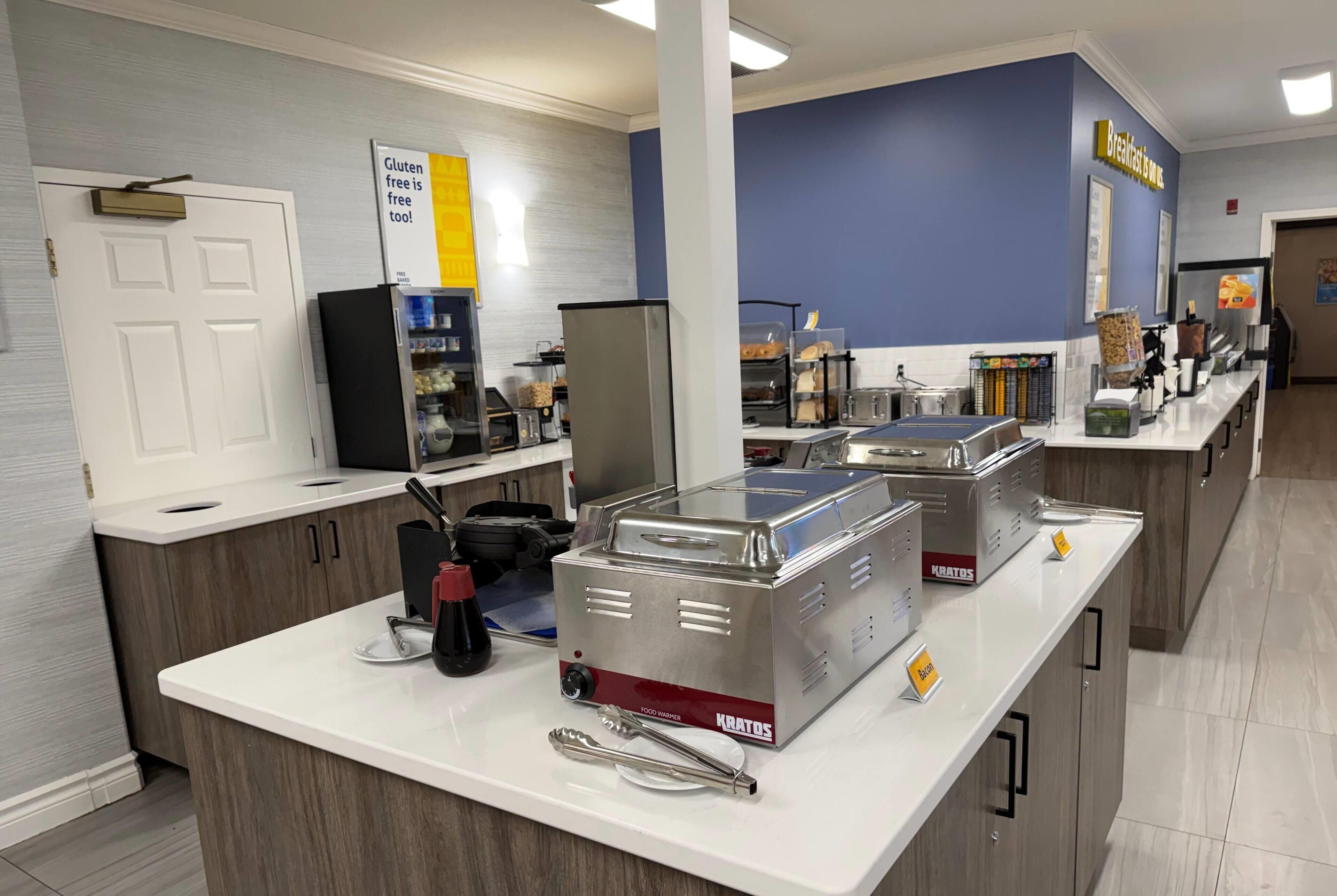 A breakfast bar with Kratos toasters, a sign indicating gluten-free options, and a variety of breakfast items.