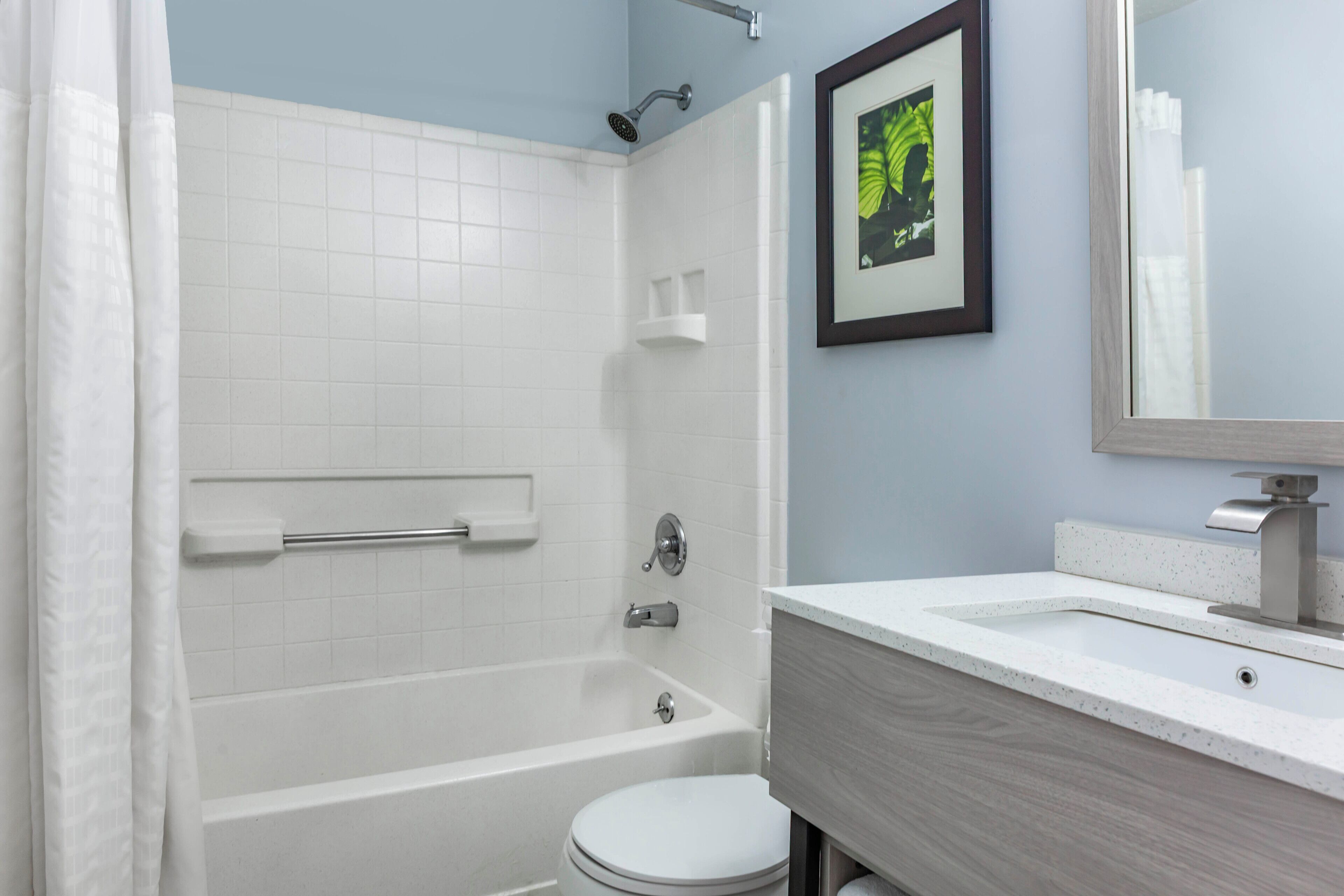 A bathroom with a bathtub, toilet, and a shower area.