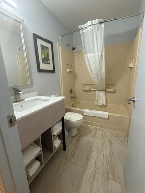Un baño con lavamanos, inodoro y bañera.