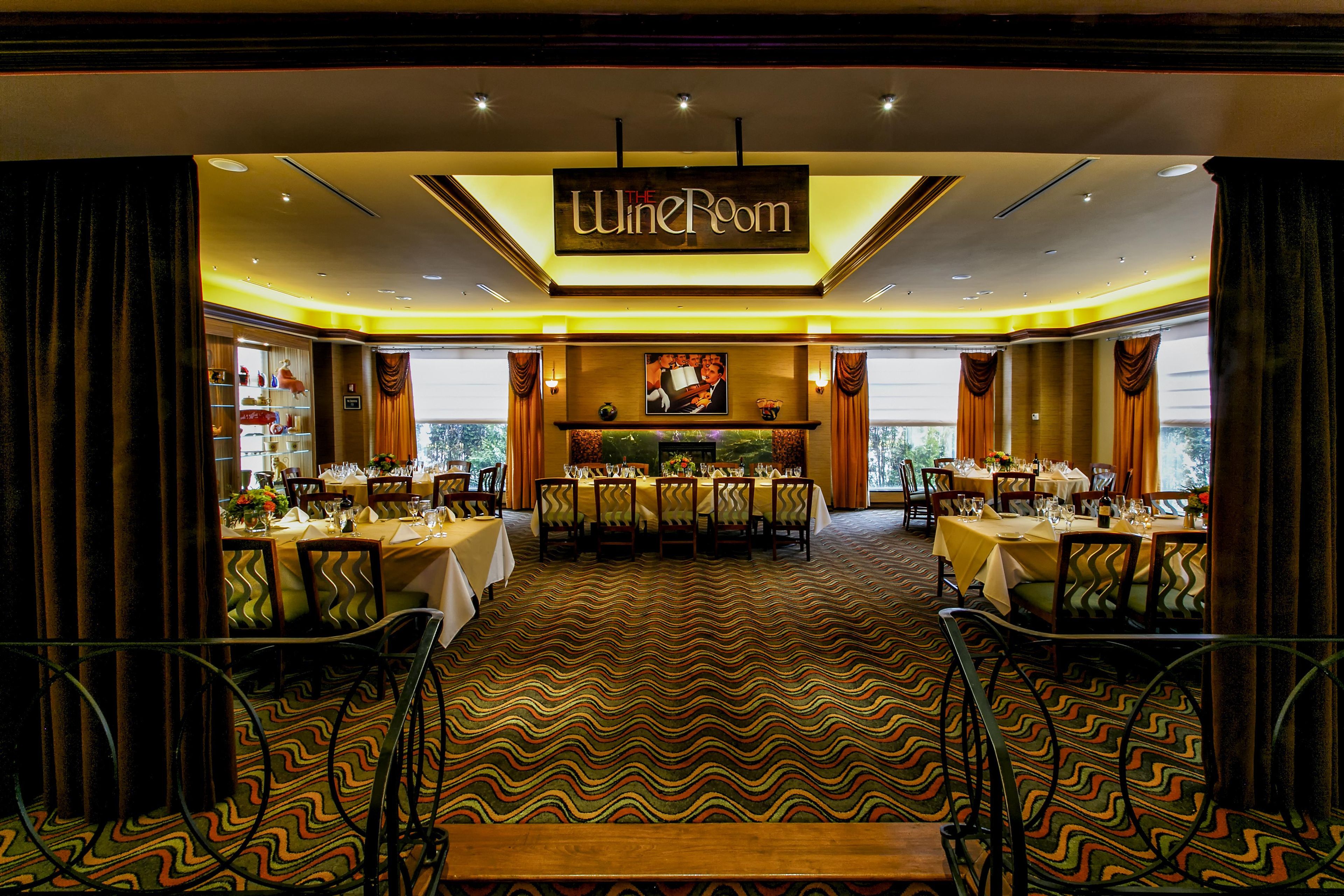 A restaurant interior with multiple dining tables, a patterned carpet, and a sign reading 'The Line Room'.