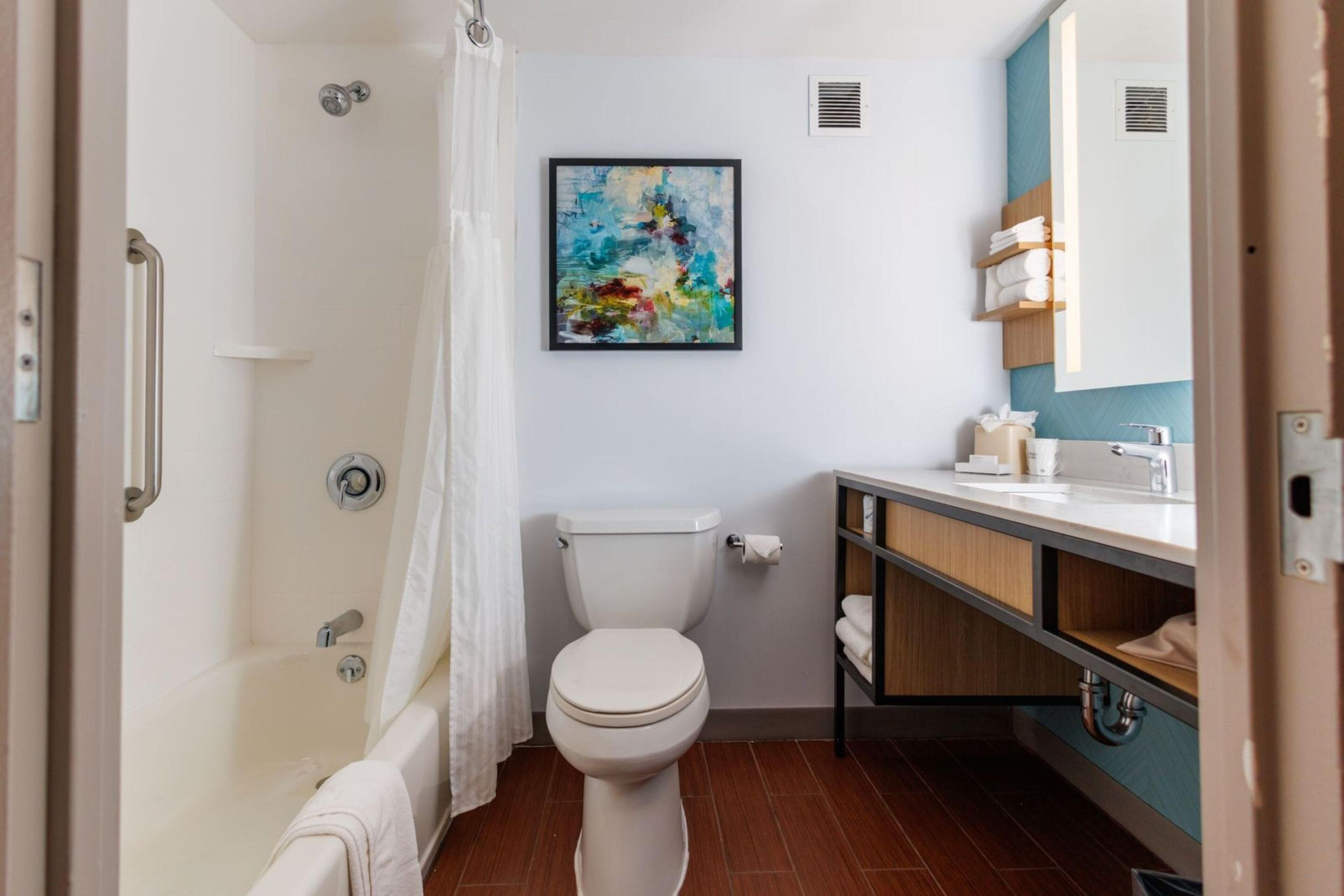 A modern bathroom with a bathtub, toilet, and sink.