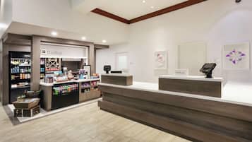 Zona de recepción de hotel con mostrador, mini bar y exhibición de mini bar.