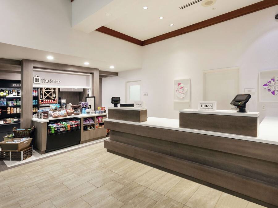 Zona de recepción de hotel con mostrador, mini bar y exhibición de mini bar.