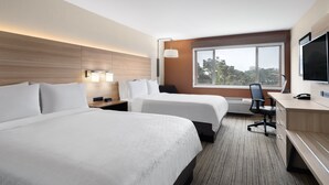 A hotel room with two beds, a desk, a chair, a TV, and a window with a view of trees. - Holiday Inn Express Ft Bragg by IHG (Fort Bragg)