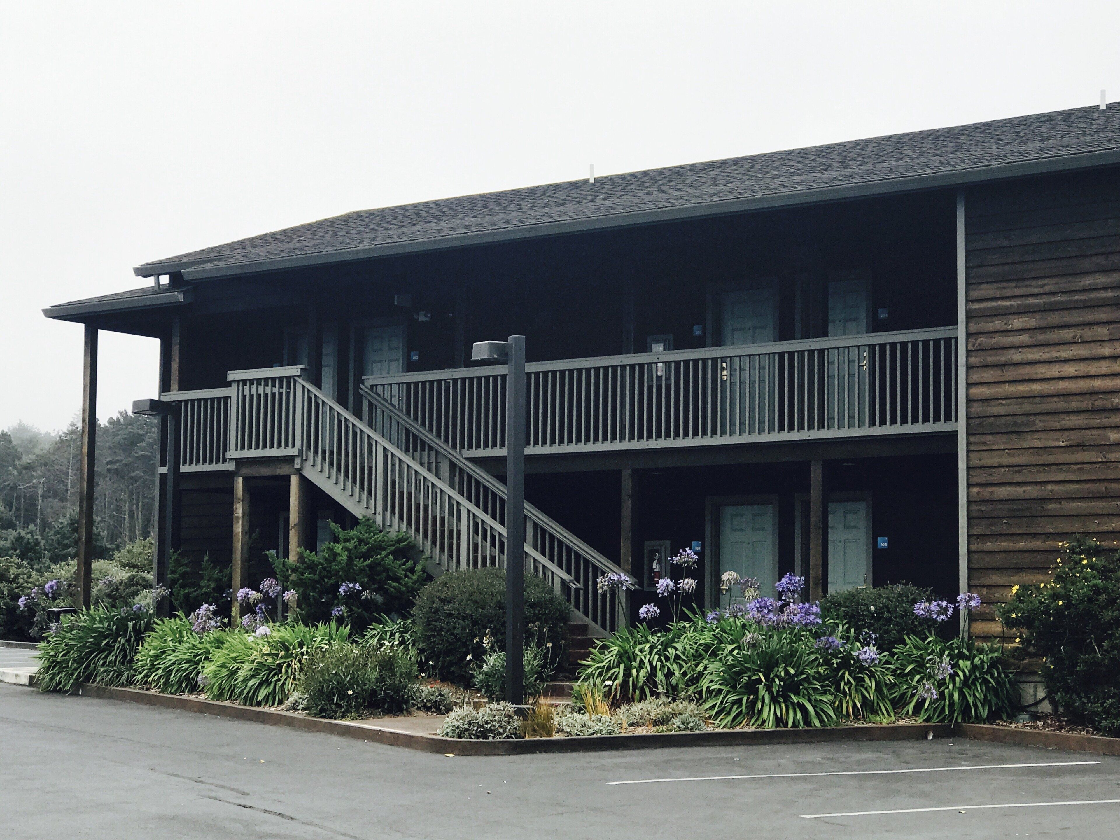 A two-story building with a balcony and a staircase.
