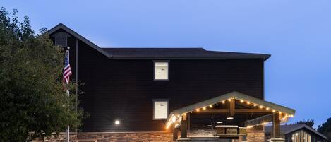 A hotel with a stone facade, a covered entrance, and an American flag.